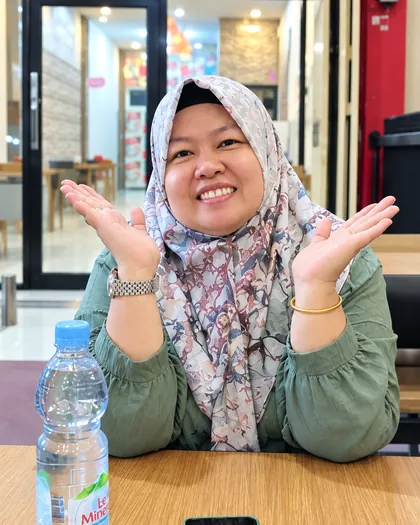 Dr. Sofiawati tersenyum ceria di meja dengan ponsel di depannya