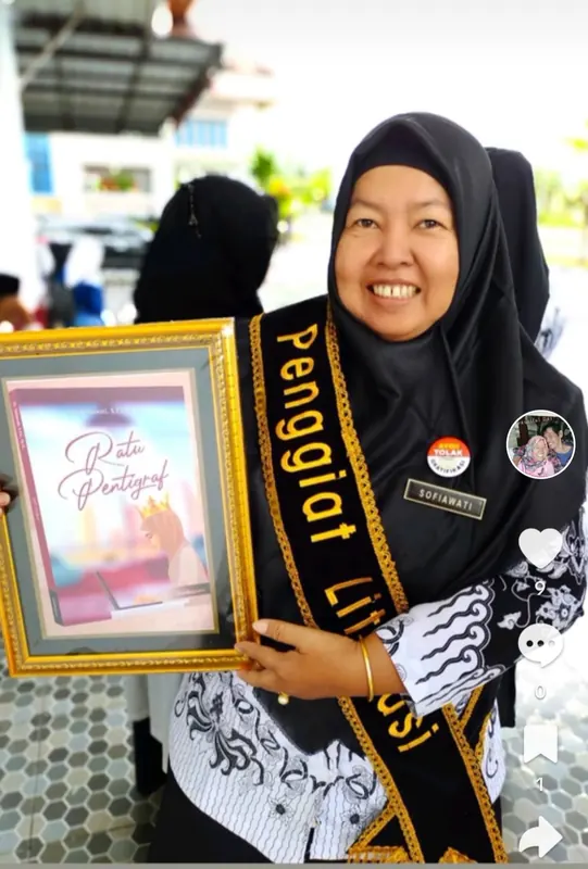 Dr. Sofiawati memegang bingkai penghargaan dengan selempang