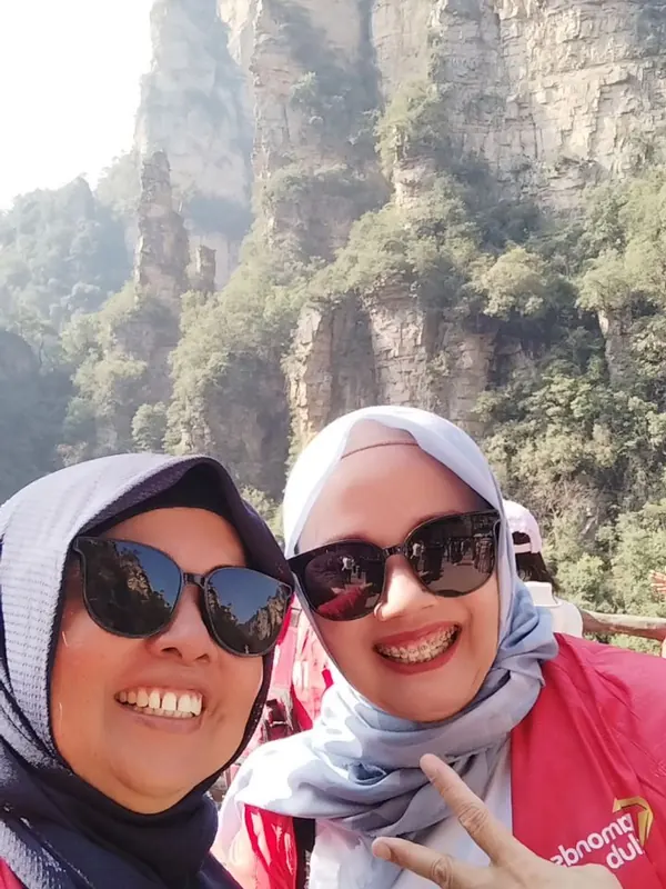 Swafoto dua sahabat berkacamata hitam dengan latar tebing