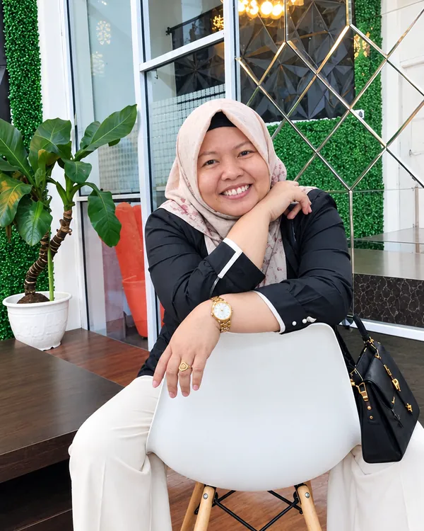 Dr. Sofiawati tersenyum, duduk santai bersandar pada kursi